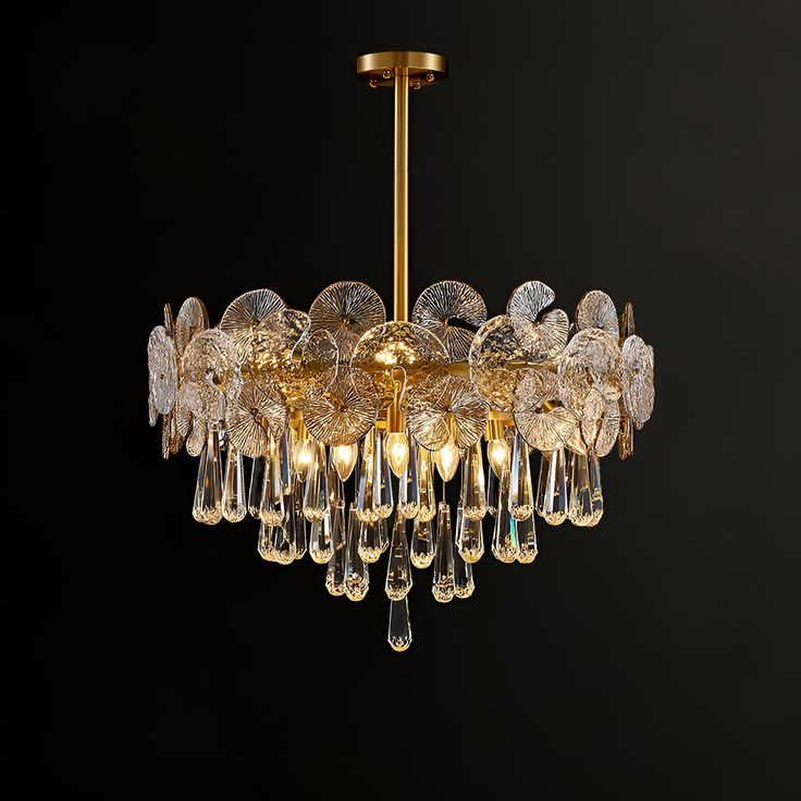 a chandelier hanging from the ceiling with clear glass drops and gold trimmings