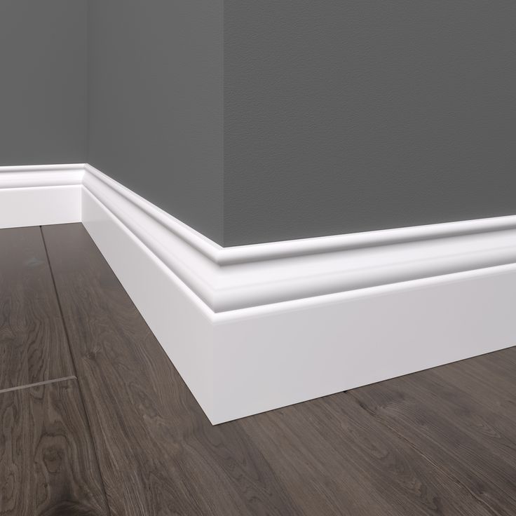 an empty room with gray walls and white trim on the floor is pictured in this image