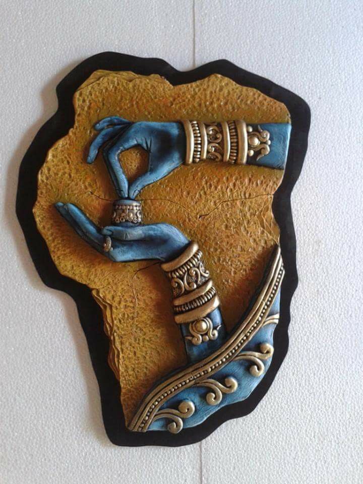 a blue and gold wall hanging on the side of a white wall with a black frame