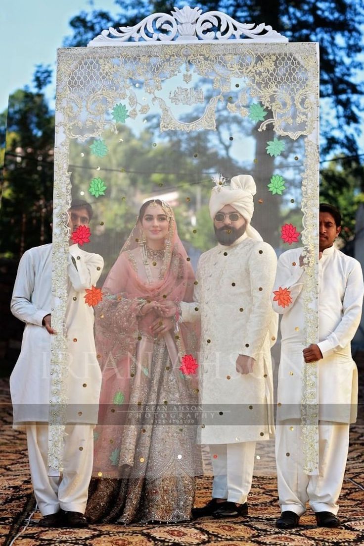 two men and a woman standing in front of a photo frame