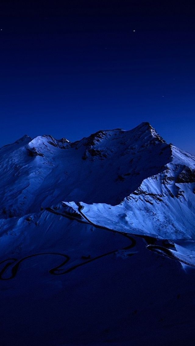 the moon shines brightly above some snowy mountains