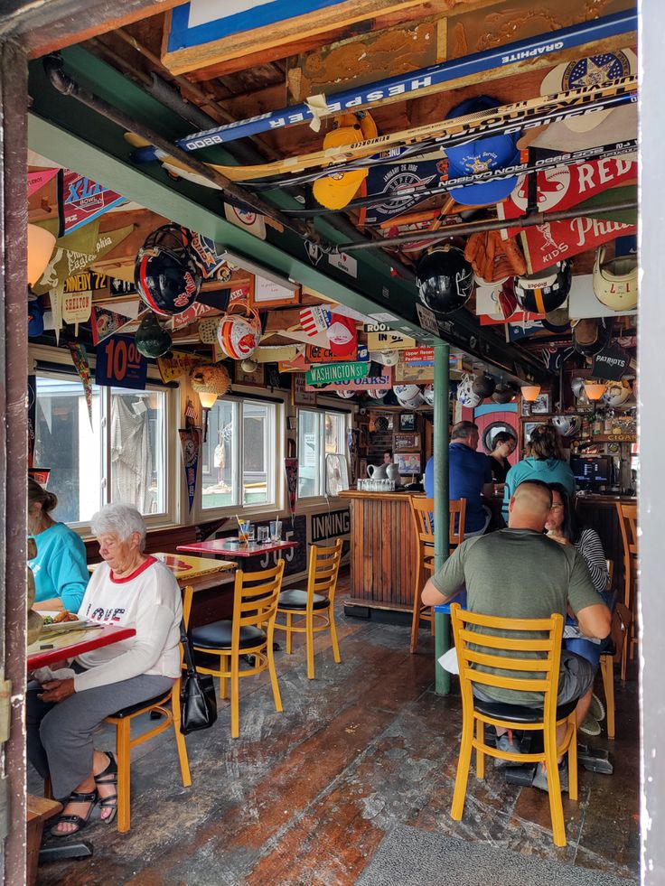 people sitting at tables in a restaurant with guitars hanging from the ceiling