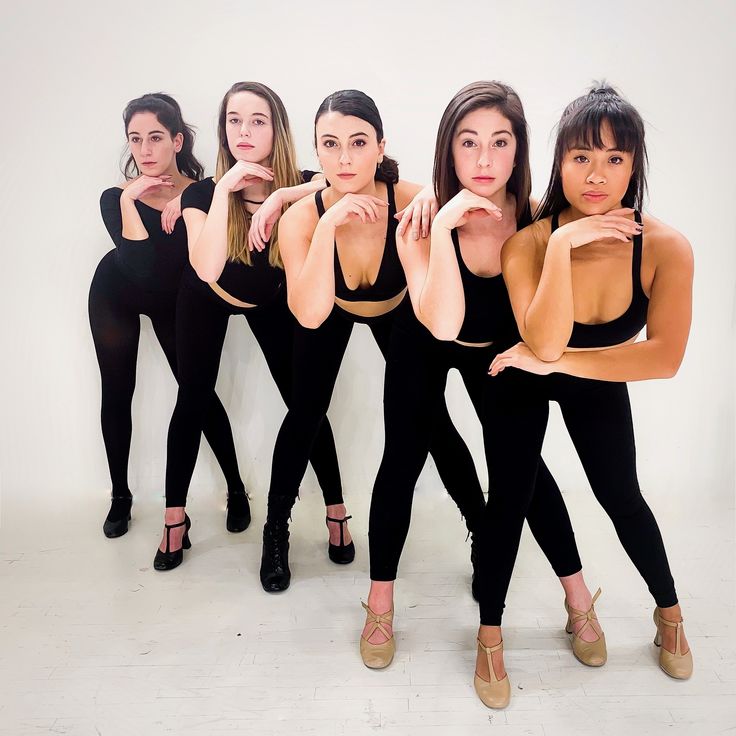 four women in black bodysuits posing for a photo together with their hands on their hips