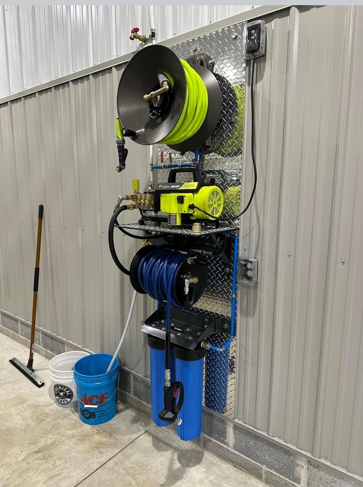 a machine is hooked up to the side of a building with buckets and tools