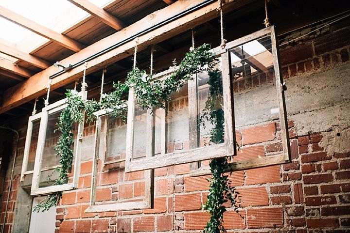 an old window with vines growing out of it's sides and hanging from the ceiling