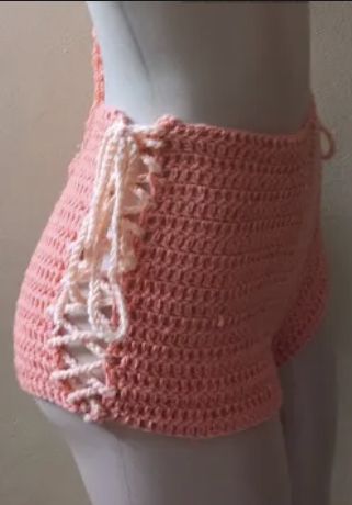 a mannequin wearing a pink crochet skirt with white lace trims