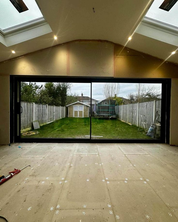 an empty room with large sliding glass doors on the outside and grass in the inside