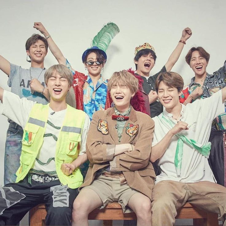 the group of young men are posing together for a photo with their arms in the air