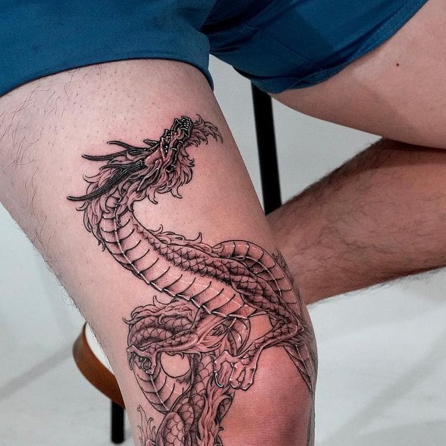 a man with a dragon tattoo on his leg