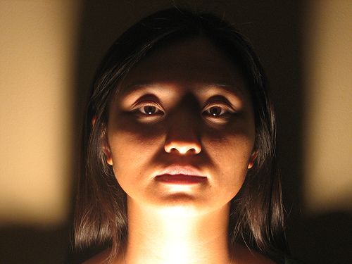 a woman's face is lit up by the light coming through her eyes