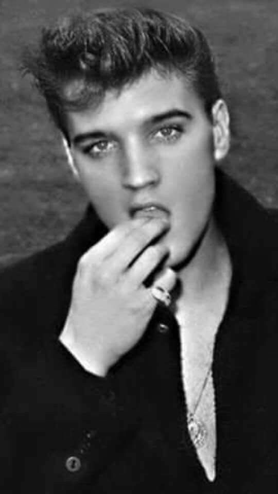 black and white photo of young man with finger to mouth, looking at the camera