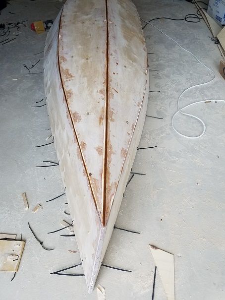 a wooden boat is being worked on in a shop or repair area with tools around it