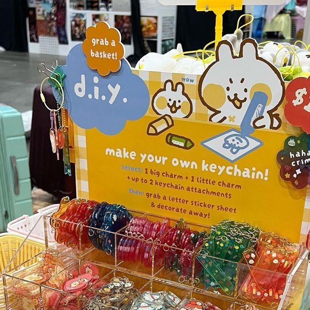 a display with lots of different colored dices on it's sides and a sign that says diy make your own keychain