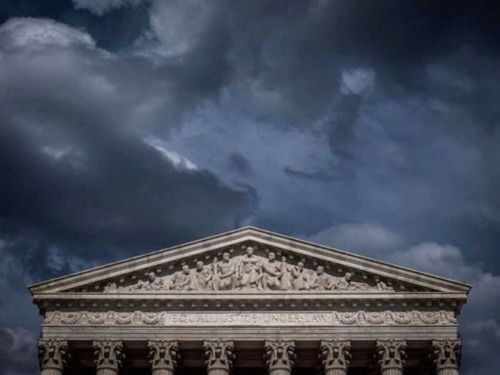 the supreme court building under a cloudy sky