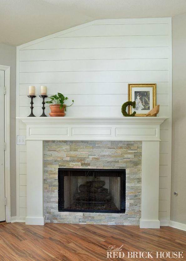 a fireplace with white painted walls and wood floors