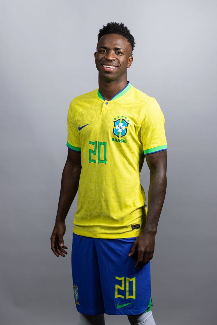 a man in a yellow shirt and blue shorts posing for a photo with his hands on his hips