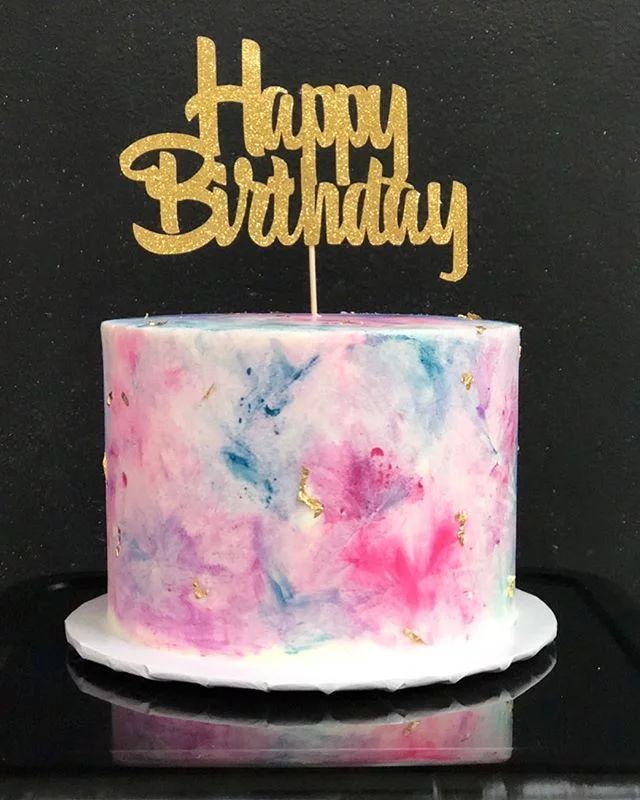 a birthday cake with the words happy birthday written on it and gold glitter topper