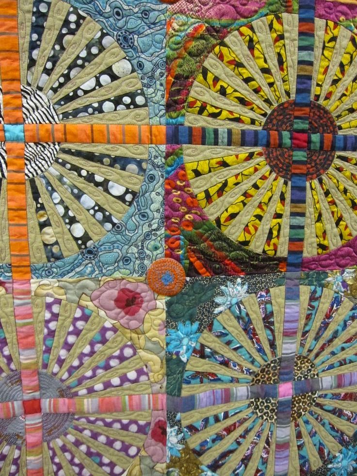 a close up of a colorful quilt with many different designs on the front and back