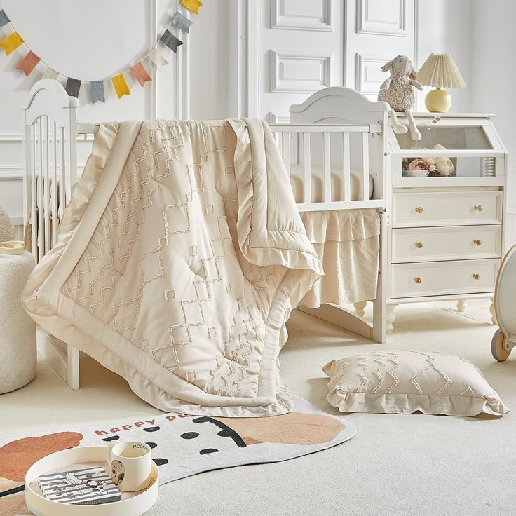 a baby's room with a crib, dresser and bedding in it