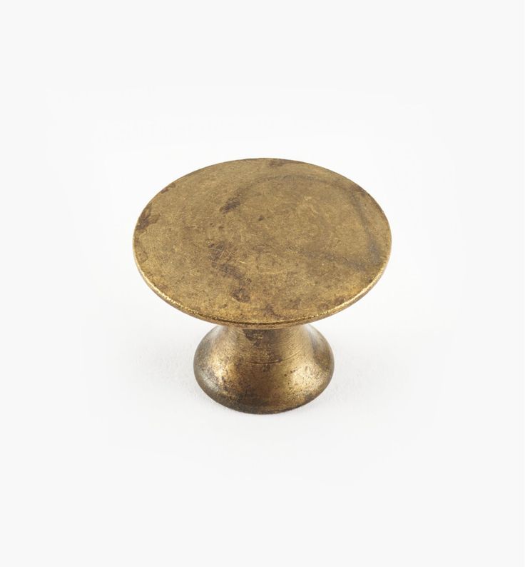 an antique brass cabinet knob on a white background