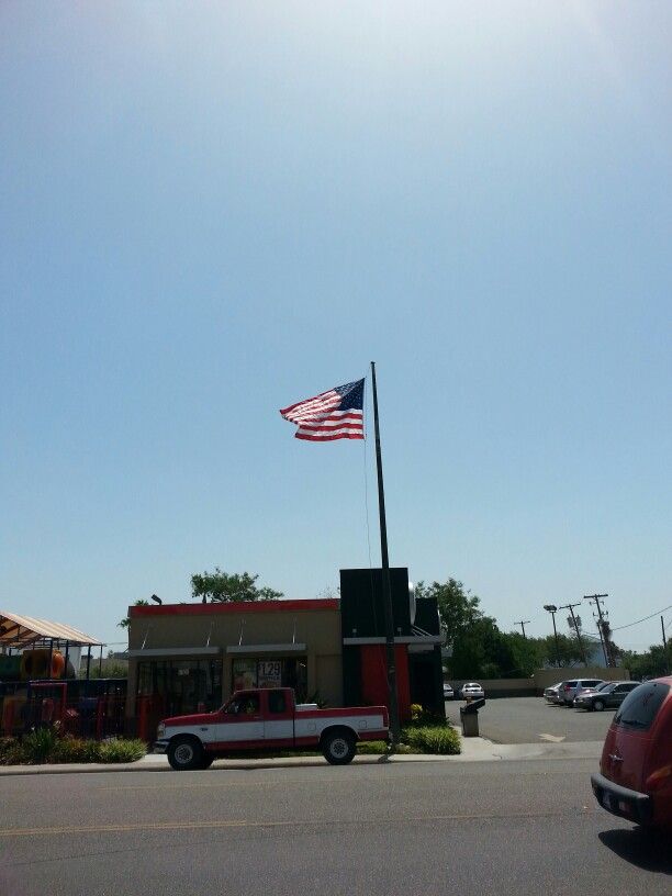 an american flag flying in the sky over a fast food restaurant