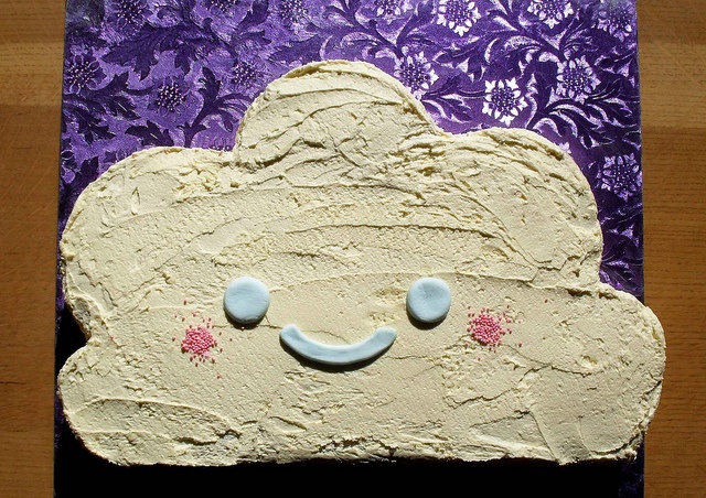 a piece of cake that looks like a cloud with two eyes and one nose on it