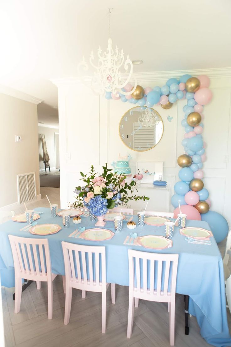 a table set up for a party with balloons