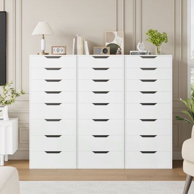 a living room with a white dresser and chair