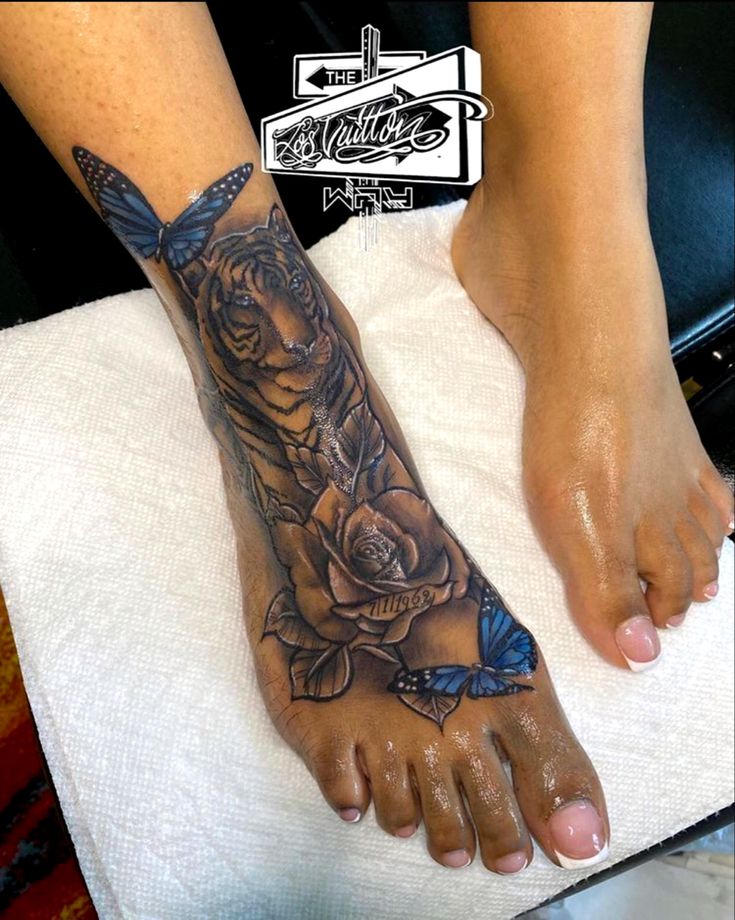 a woman's foot with a rose and butterfly tattoo on it