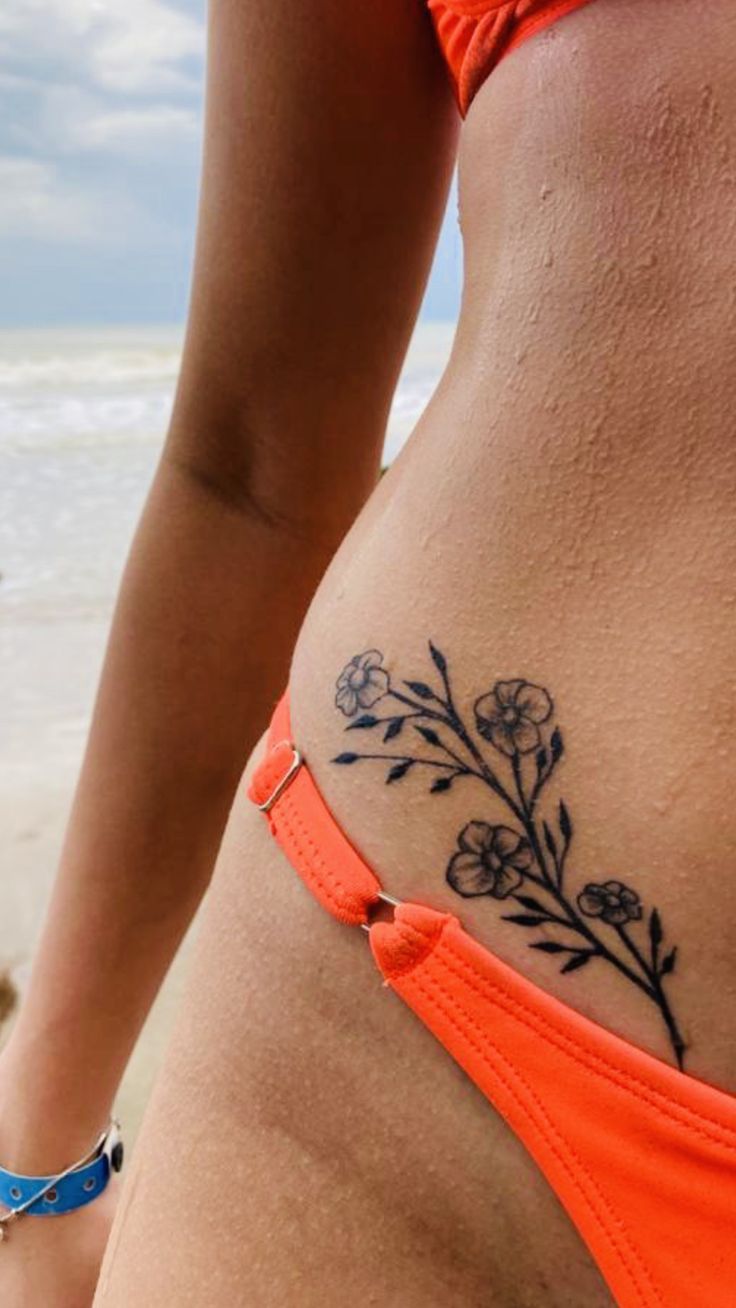 a woman with a flower tattoo on her stomach