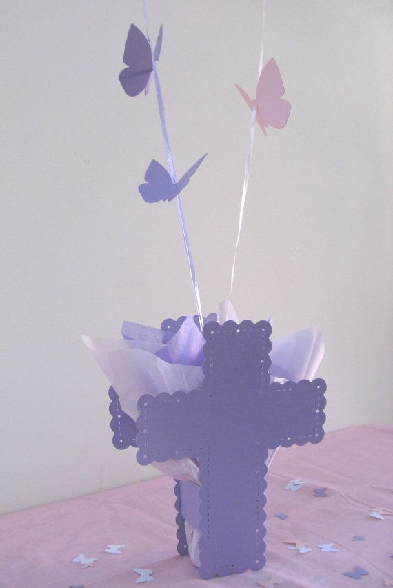 a vase filled with paper flowers on top of a pink table cloth covered tablecloth