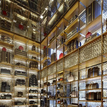 a large room filled with lots of furniture and shelves full of purses on display