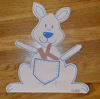 a paper cut out of a dog with a pocket in it's lap on a wooden surface