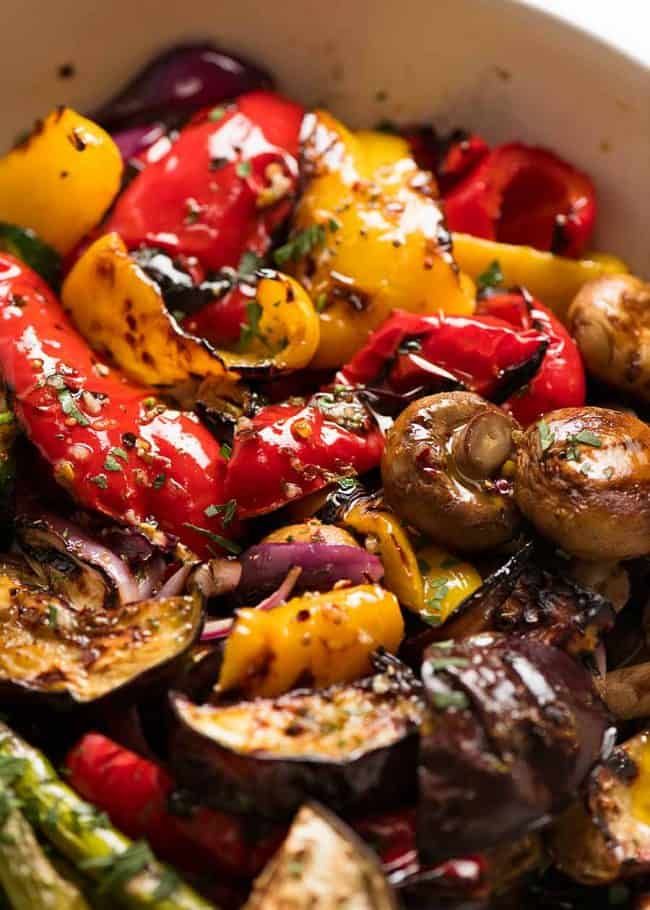 a white bowl filled with lots of different types of veggies on top of each other