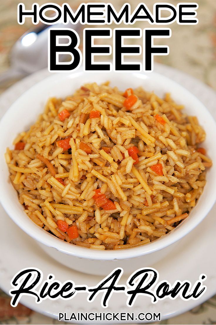 a bowl filled with rice and carrots on top of a white plate next to a spoon