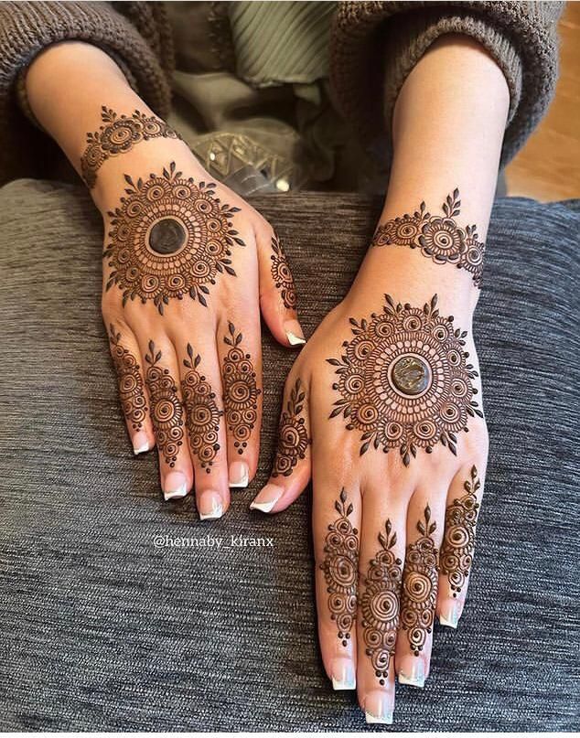 two hands with henna tattoos on them