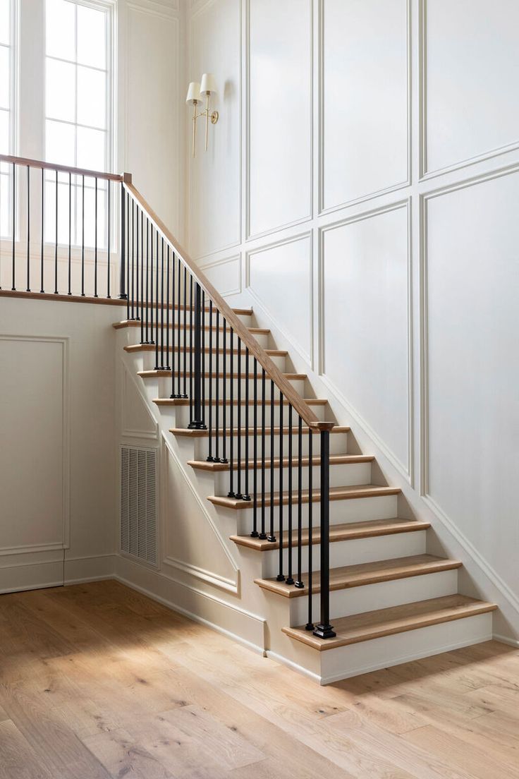 an empty room with some stairs and white paint on the walls, along with wood flooring