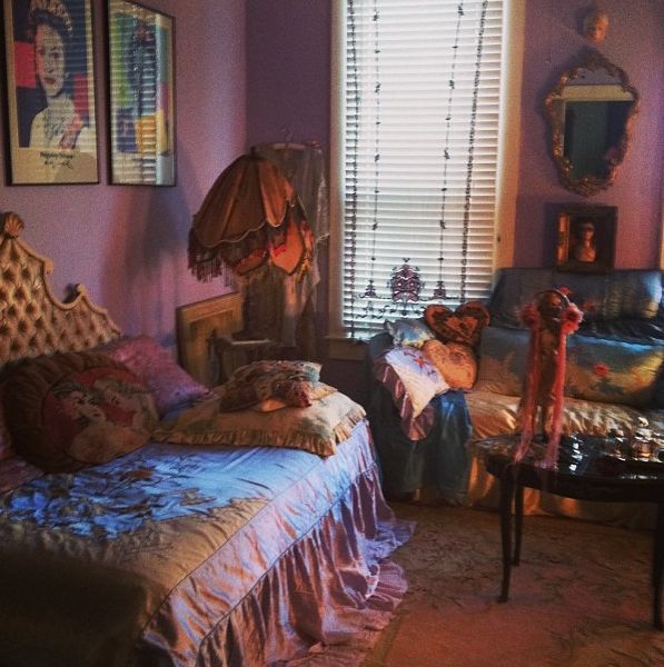 a bedroom with purple walls and pictures on the wall