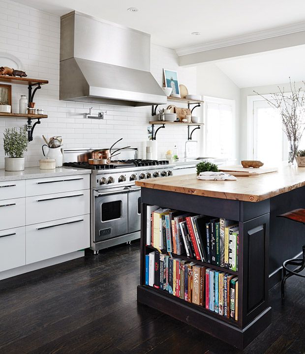 a kitchen with an island and bookshelf filled with cookbooks on the counter