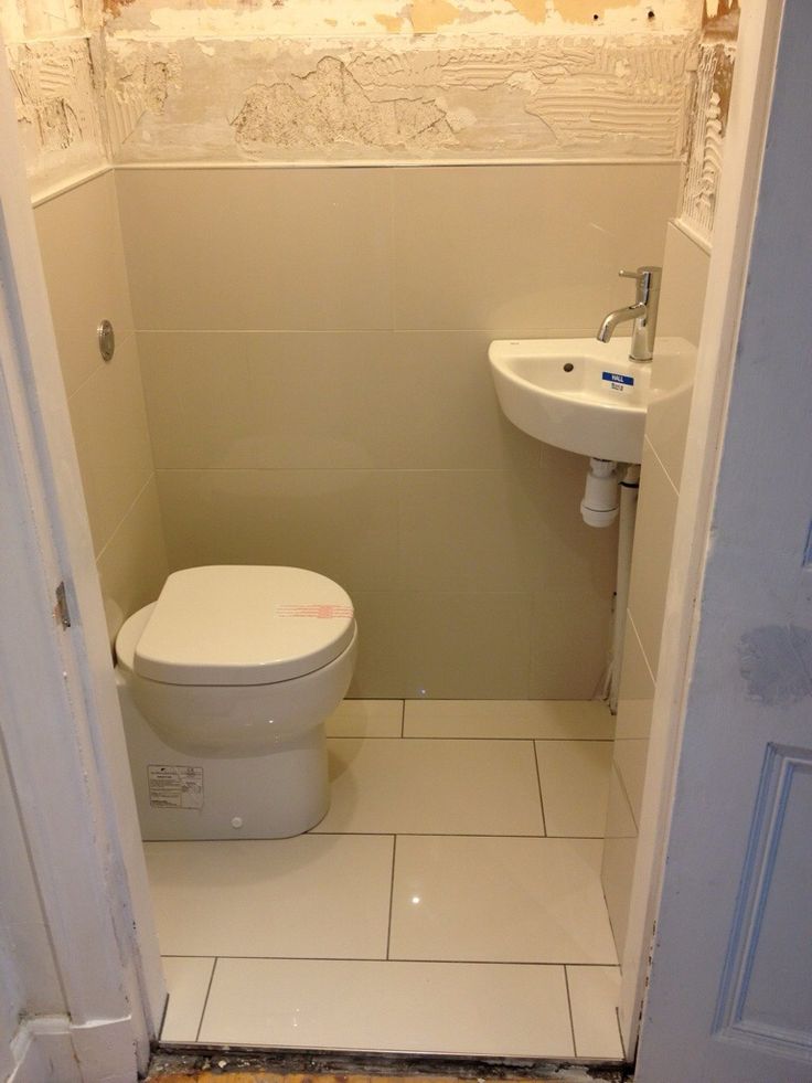 a white toilet sitting inside of a bathroom next to a sink under construction on the wall