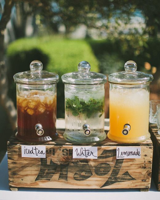 three jars filled with drinks sitting on top of a wooden box next to each other