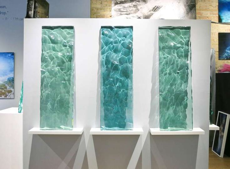 three different colored glass panels on display in a room