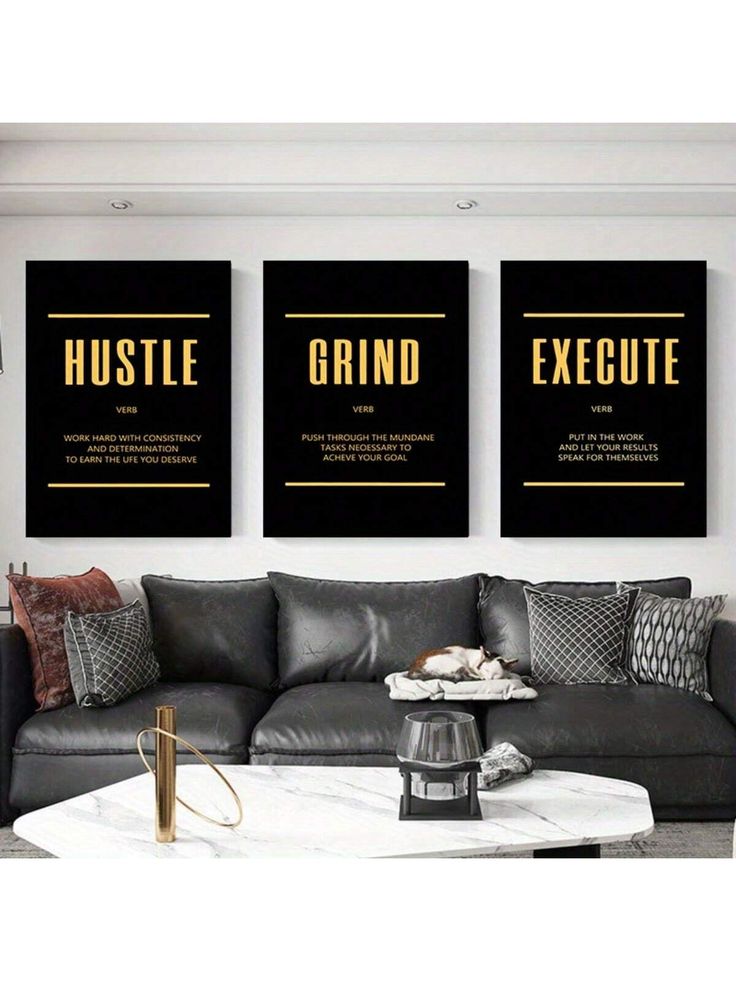 three black and gold posters on the wall above a gray couch in a living room