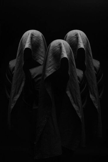 three cloth covered heads in black and white