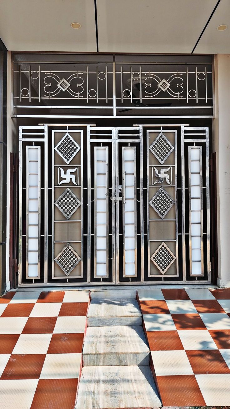 an entrance to a building with metal gates and checkered flooring on the outside