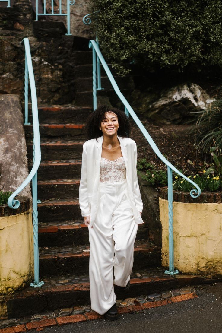 a woman in white is standing on some steps