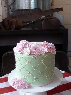 a green cake with pink flowers on top