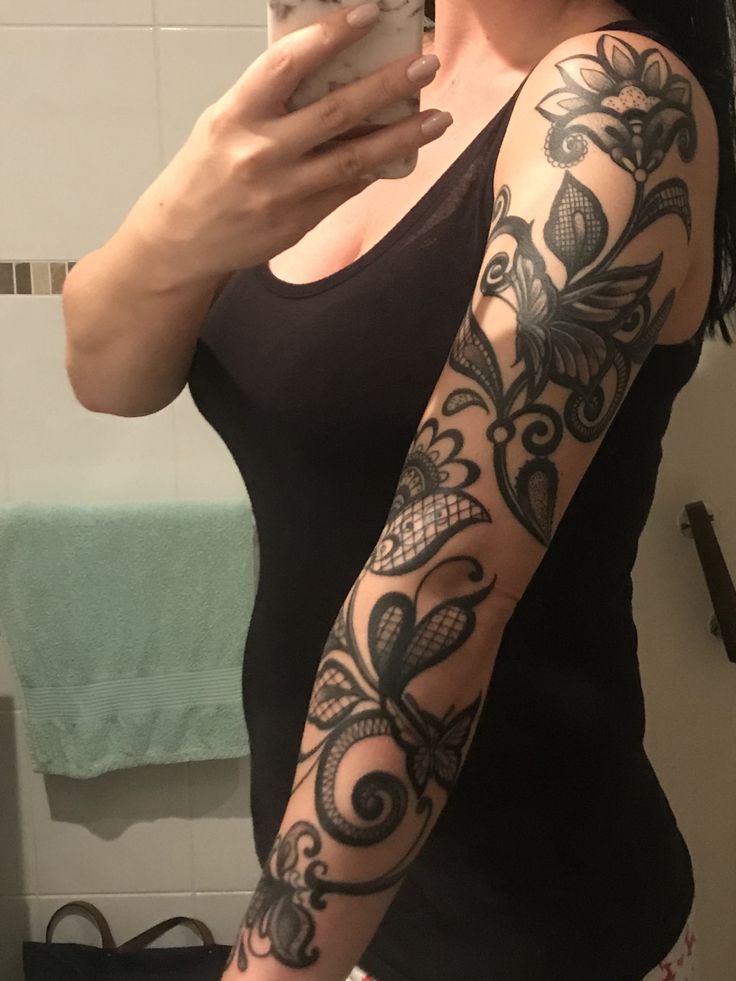 a woman is taking a selfie in the mirror with her cell phone and tattoos on her arm