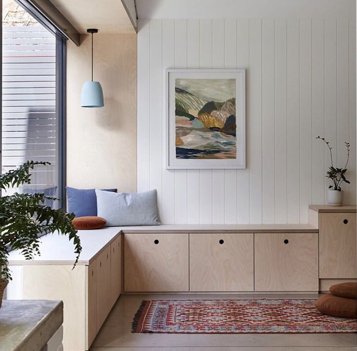 a living room filled with furniture and a painting hanging on the wall over a window