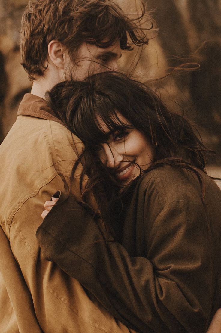 a man and woman hugging each other outside